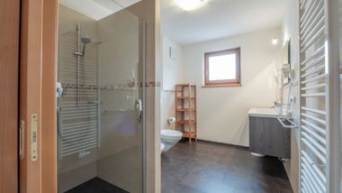 Bathroom with a window, shower, washbasin, toilet, and bidet