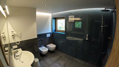 Bathroom with a window, shower, washbasin, toilet, and bidet