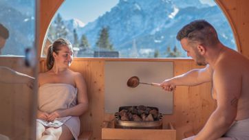 A couple is doing an Aufguss in the sauna