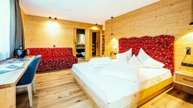 Una camera da letto matrimoniale con scrivania e divano