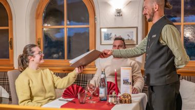 A waiter is handing out the menu