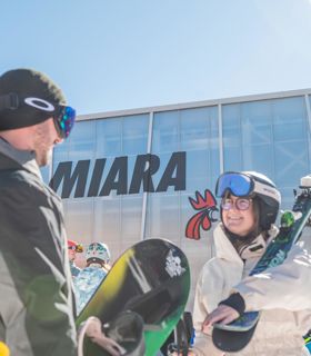 Due sportivi invernali davanti alla stazione a valle Miara