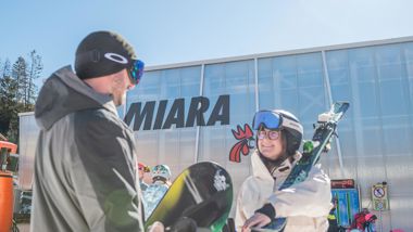Due sportivi invernali davanti alla stazione a valle Miara
